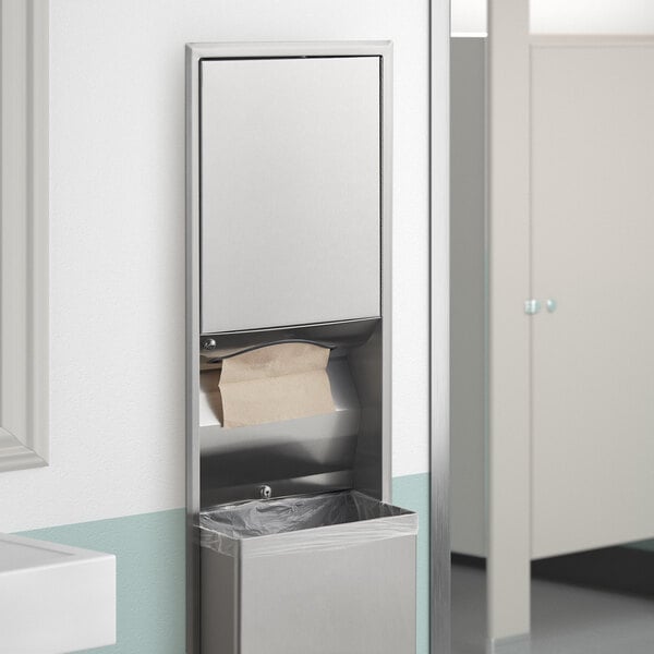 A Bobrick recessed paper towel dispenser and waste receptacle in a bathroom.