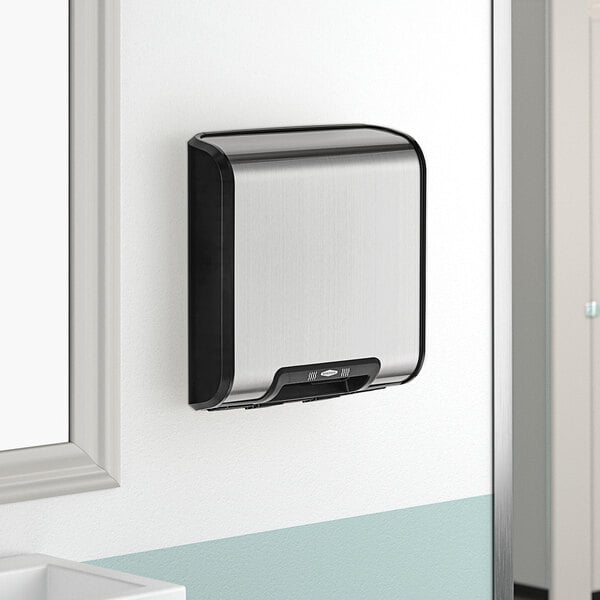 A Bobrick silver and black stainless steel wall-mounted hand dryer.