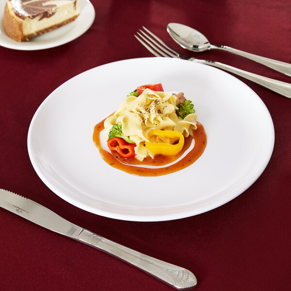 A Carlisle white melamine plate with food and a knife on it.