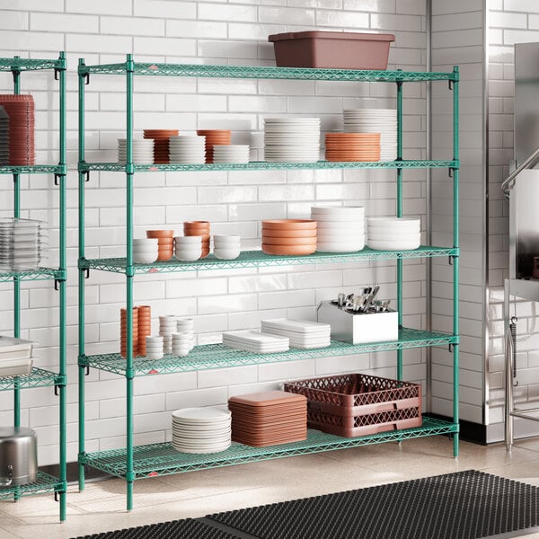 A large green wire shelving unit with multiple shelves holding various kitchen dishes and containers.