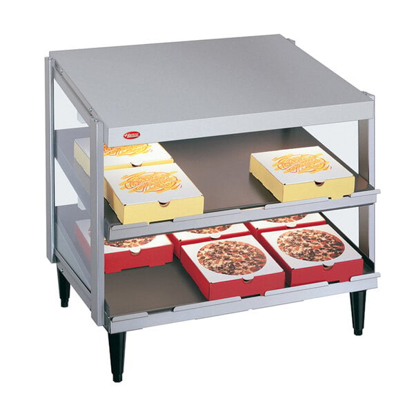 A Hatco countertop pizza warmer with pizza boxes on the shelves.