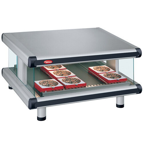 A Hatco countertop food warmer with pizza on a slanted shelf.