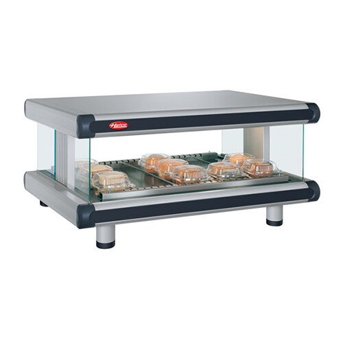 A glass tray with food on a Hatco countertop warmer.