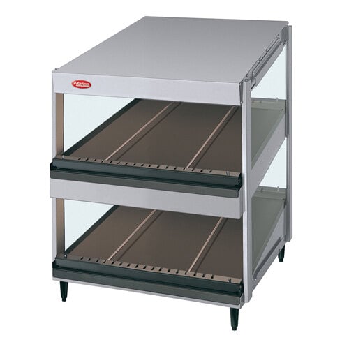 A Hatco slanted double shelf merchandiser with metal shelves on a white countertop.