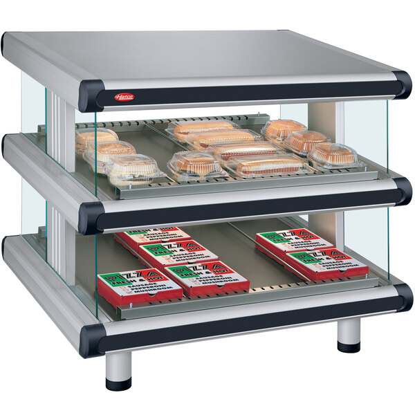 A Hatco Glo-Ray double shelf merchandiser with food trays on it.