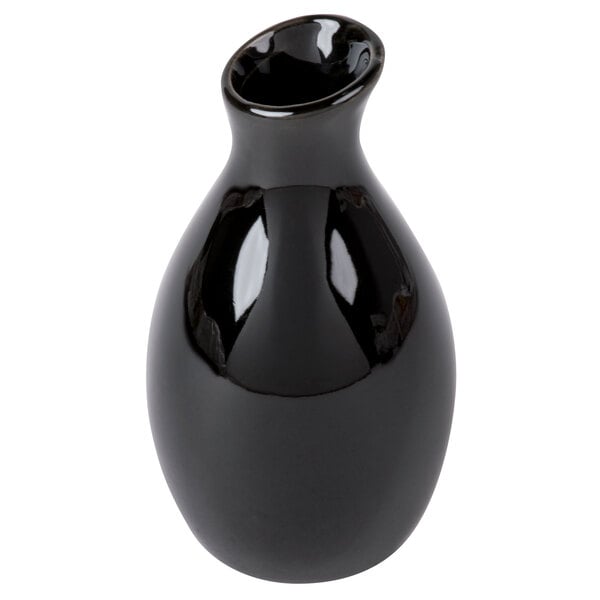 A close-up of a black American Metalcraft ceramic jug vase.