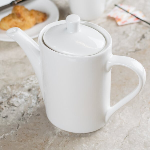 A white Tuxton Modena AlumaTux coffee pot on a table.