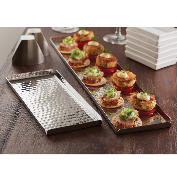 An American Metalcraft hammered stainless steel tray with appetizers on a table.