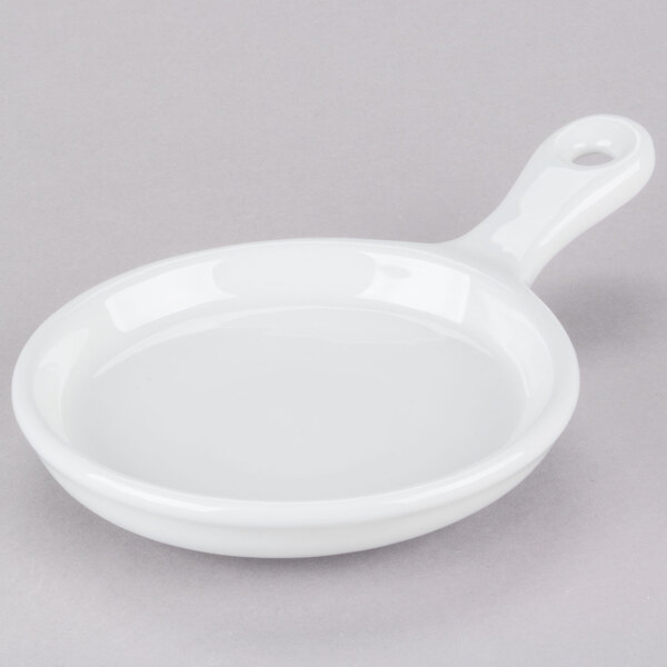 A white round pan with a handle.
