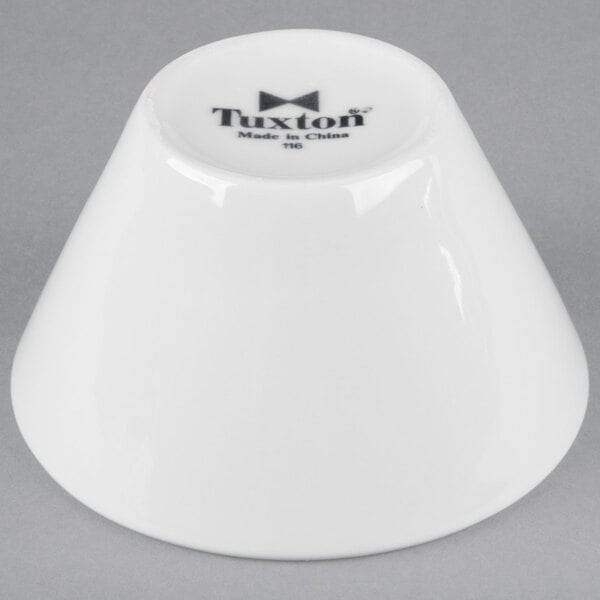 A bright white Tuxton china bouillon cup with black Tuxton text.