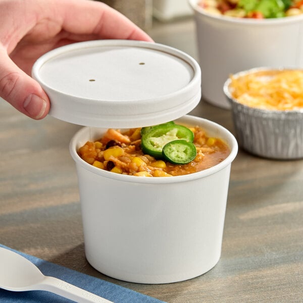 A 12 oz. white paper food cup with a vented paper lid, partially open to reveal soup or chili inside.