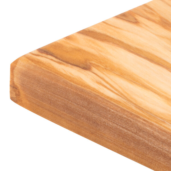 An American Metalcraft olive wood serving board on a wood surface.