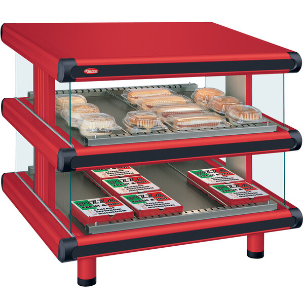 A red Hatco warm food display case with two shelves holding food items.