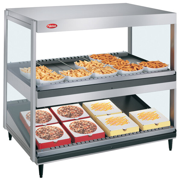 A Hatco countertop food warmer with trays of french fries on shelves.