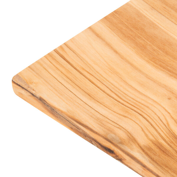 An American Metalcraft olive wood serving board on a wood surface.