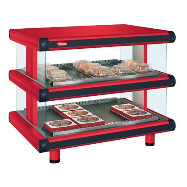 A red and black Hatco countertop display case with food on trays.
