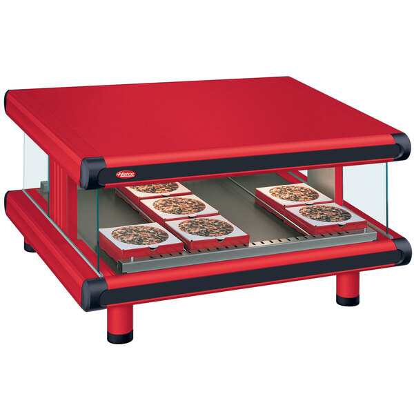 A red Hatco warm food merchandiser with trays of pizza on a table.