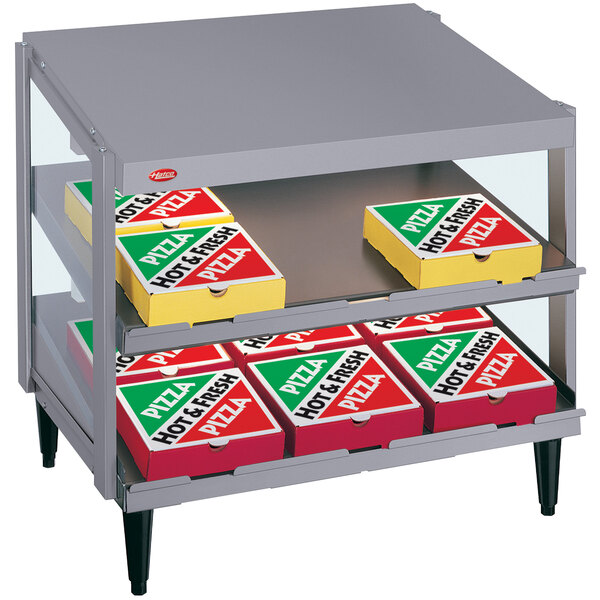 A Hatco countertop pizza warmer shelf with pizza boxes inside.