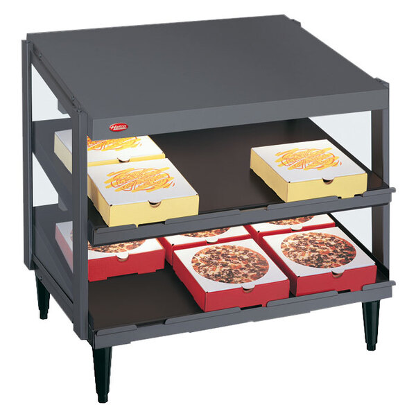 A Hatco granite gray double shelf pizza warmer with pizza boxes on the shelves.