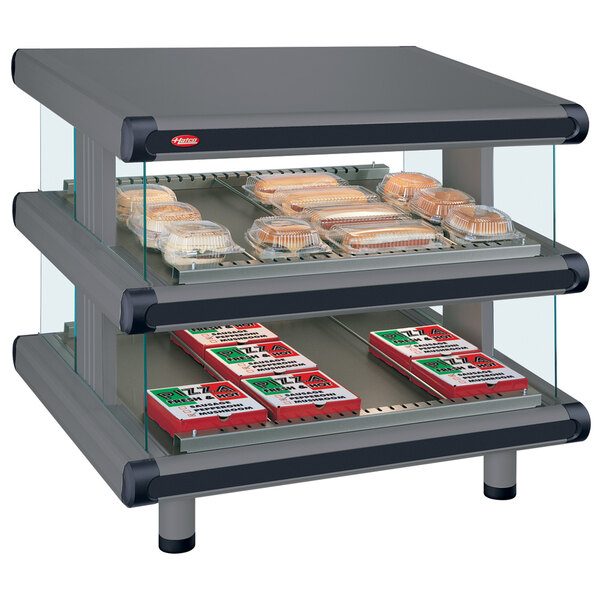 A Hatco countertop display case with food trays on double slanted shelves.