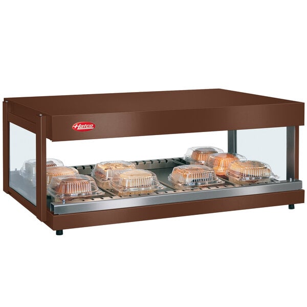 A brown Hatco countertop food warmer with breads on a shelf.