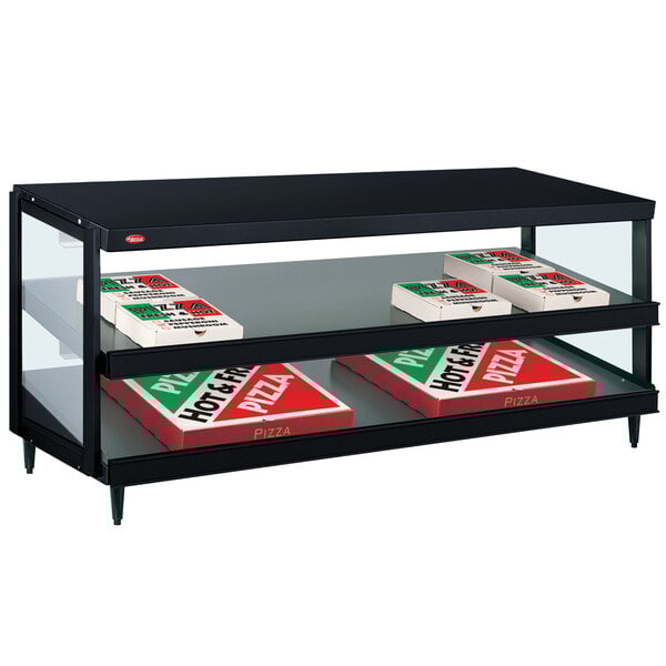 A black Hatco countertop display shelf with pizza boxes on it.