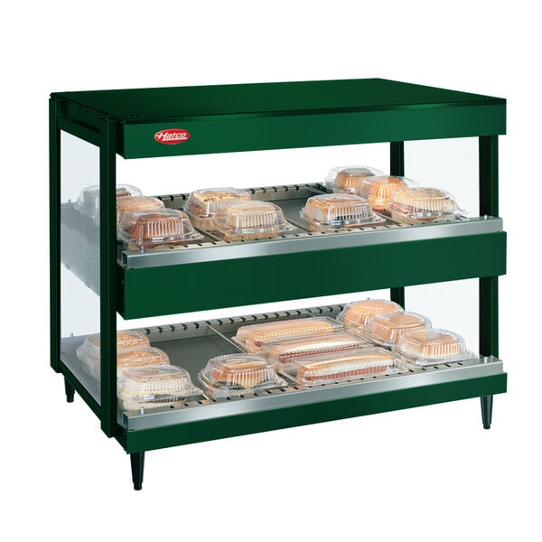 A Hunter Green Hatco countertop display case with trays of food.