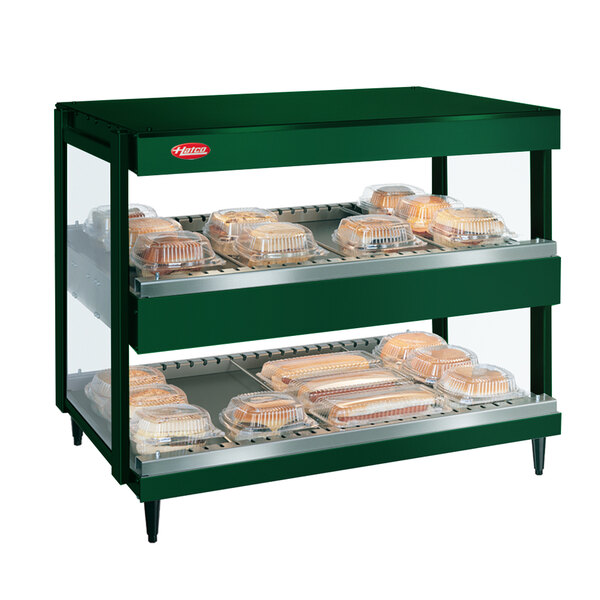A Hunter Green Hatco countertop display case with trays of food.