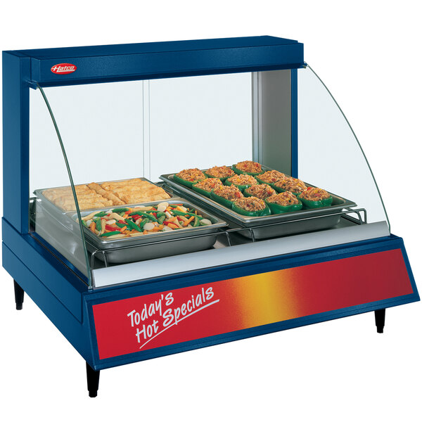 A blue Hatco countertop display case with trays of food.