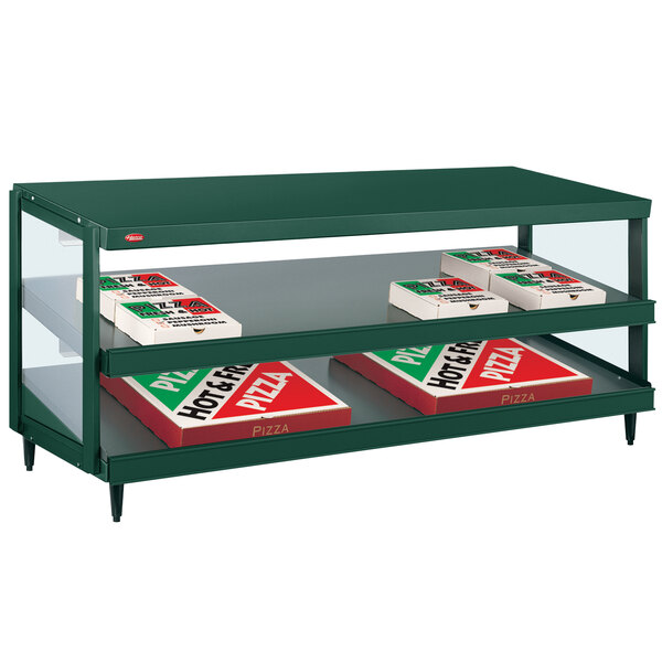 A green Hatco countertop display shelf with pizza boxes on it.