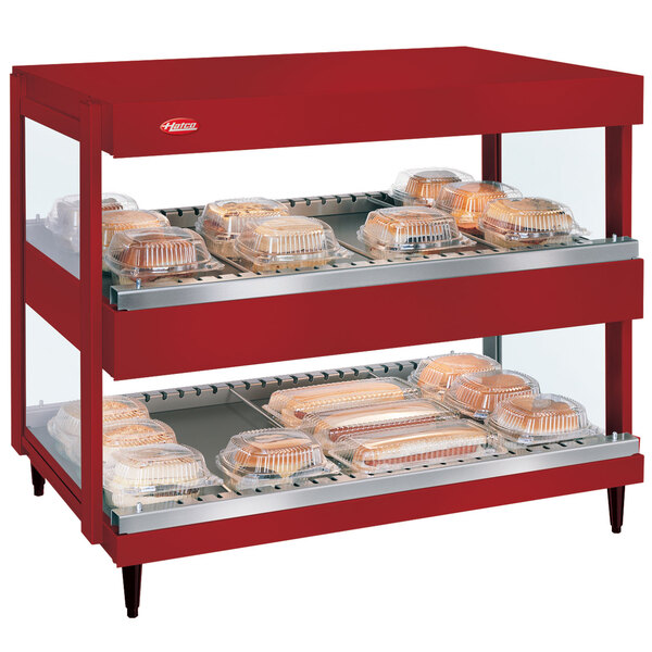 A Hatco red countertop food warmer with trays of food.