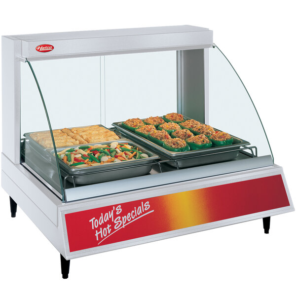 A Hatco countertop food display warmer with food on a tray inside a glass display case.