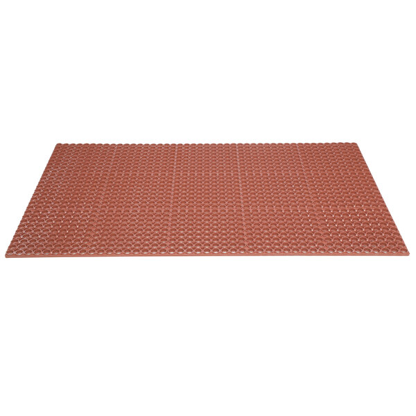 A close-up of a large red Notrax rubber mat with holes in it.