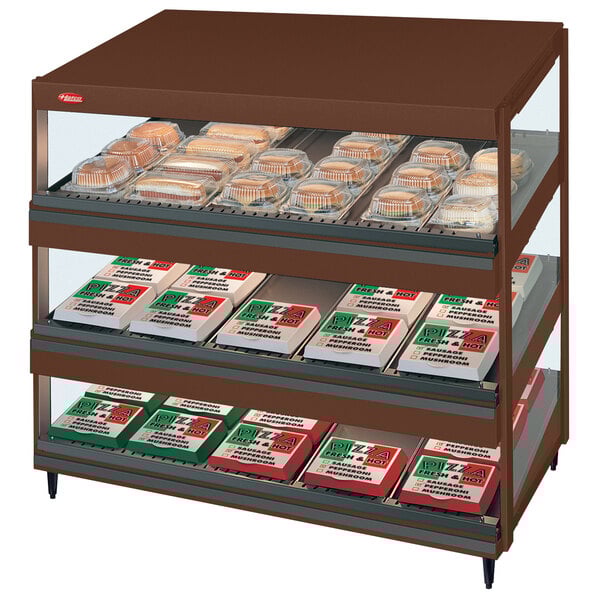 A Hatco slanted countertop display case with food on shelves.