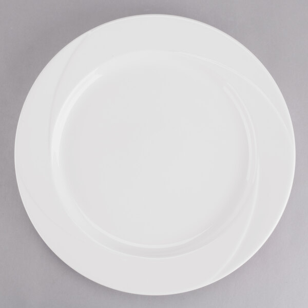 A Tuxton AlumaTux Pearl White china plate with a curved edge.