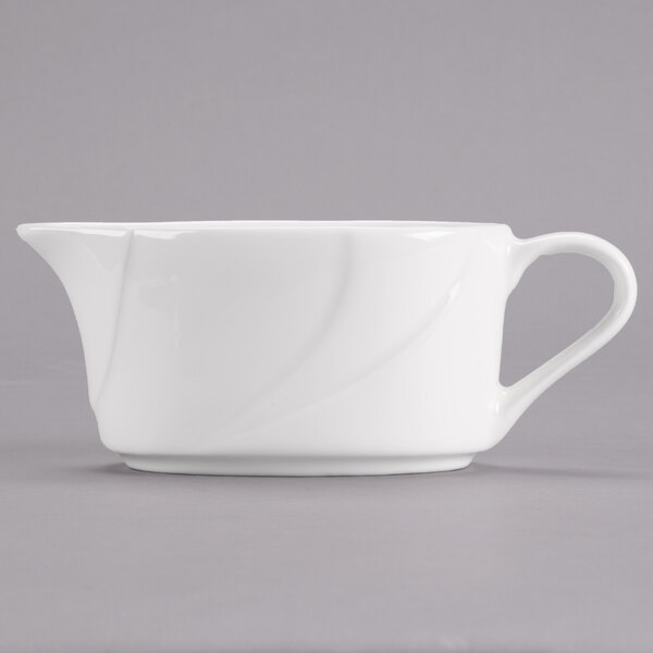 A Tuxton San Marino AlumaTux Pearl White china gravy boat with a handle.