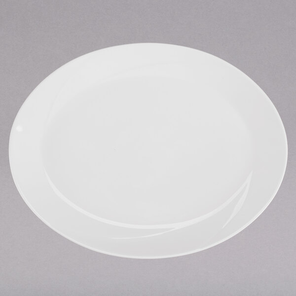 A Tuxton San Marino AlumaTux Pearl White oval china platter on a gray surface.