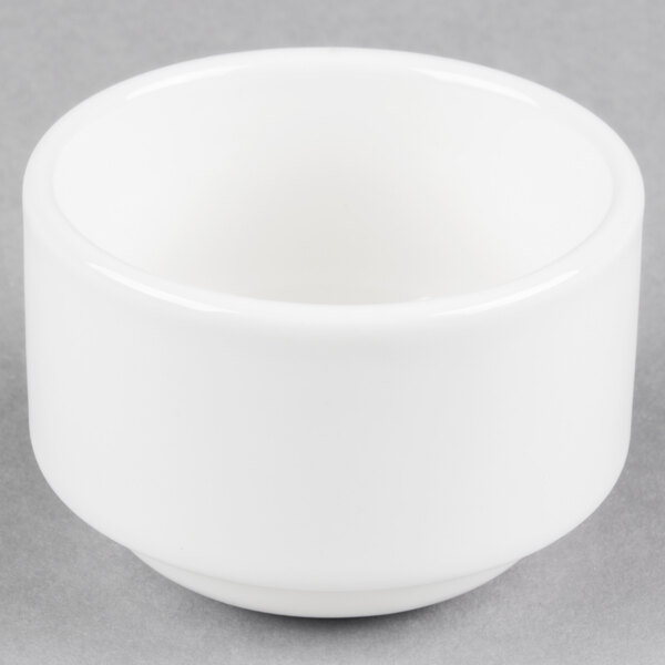 A close up of a Tuxton AlumaTux Pearl White ramekin on a gray surface.