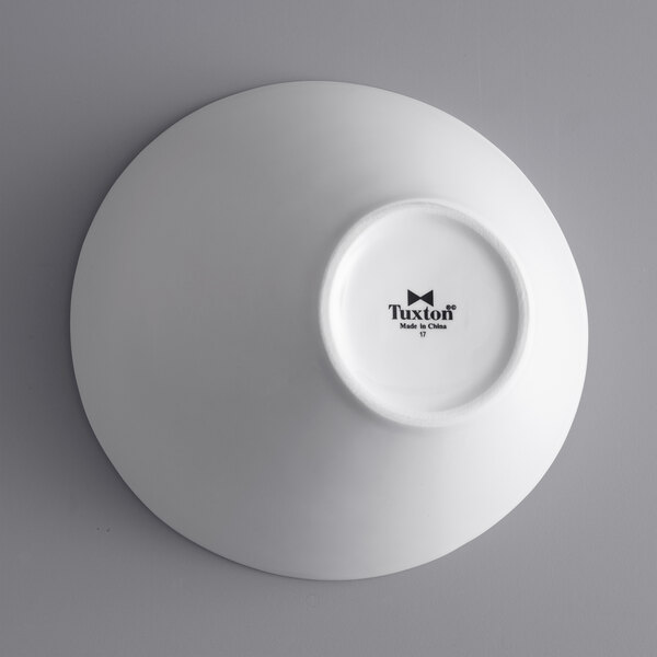 A white Tuxton china bowl with black text on it.