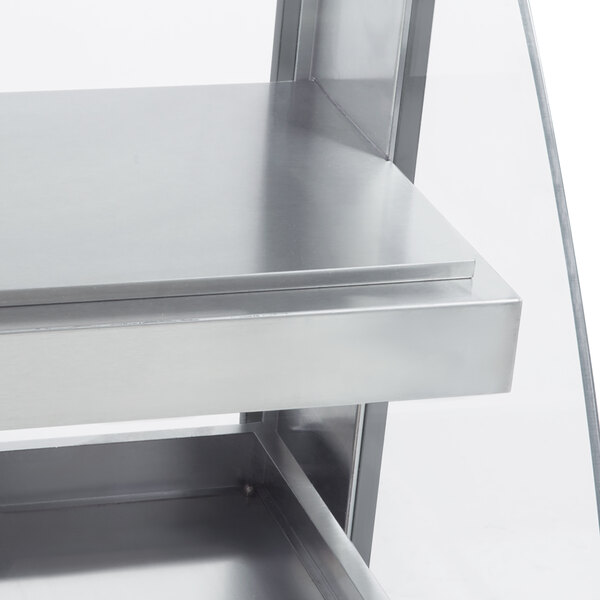 A silver metal shelf with a glass top on a countertop.