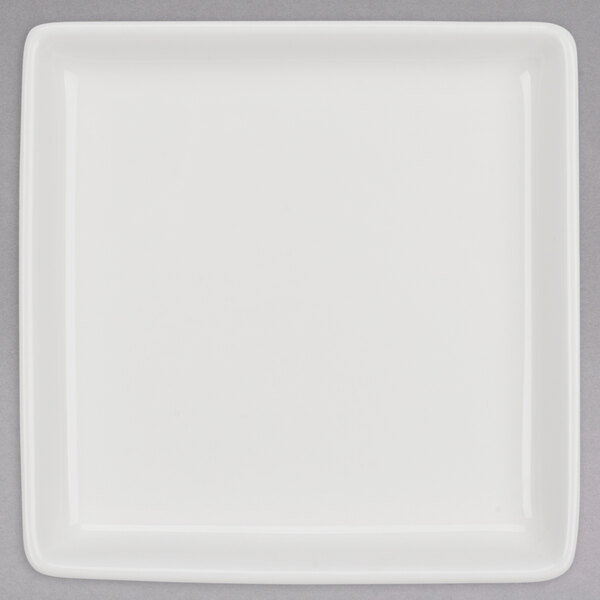 A Tuxton AlumaTux white square china plate on a gray surface.