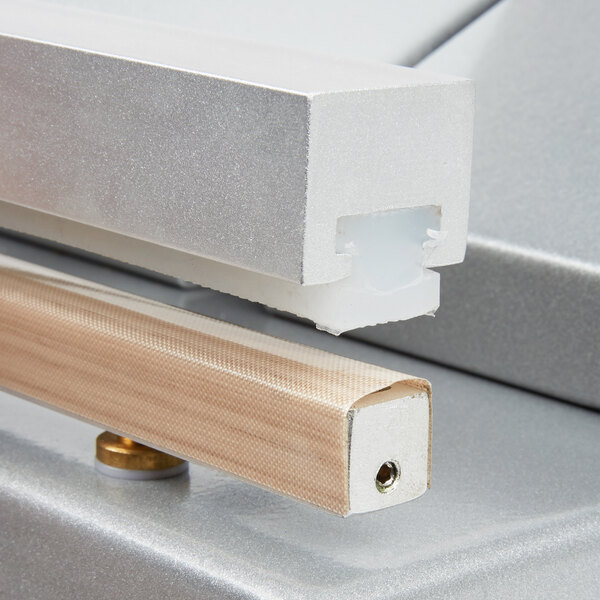 A close-up of a metal piece with a wooden handle.