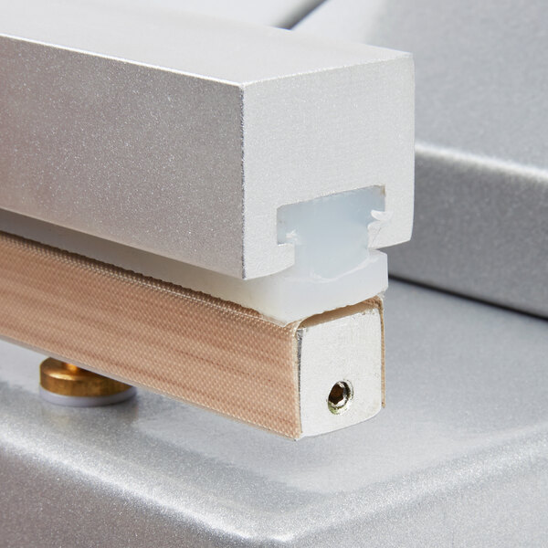 A close-up of a metal ARY VacMaster seal bar tape.