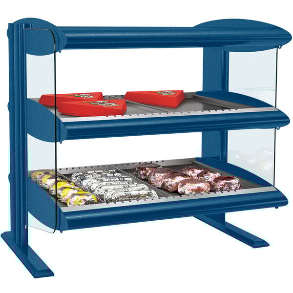 A navy blue Hatco countertop display case with shelves holding red and white candy.
