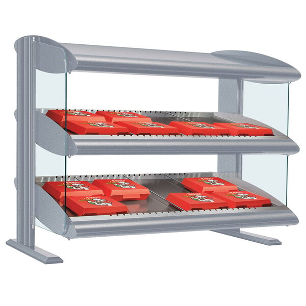 A Hatco white granite LED slanted shelf food display case on a counter with red trays.