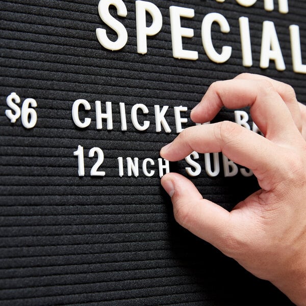 A person using Aarco Helvetica letter and number set to change a sign.