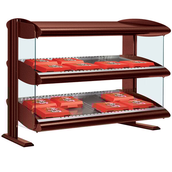 A Hatco horizontal shelf merchandiser with red trays holding red boxes on a table in a bakery display.