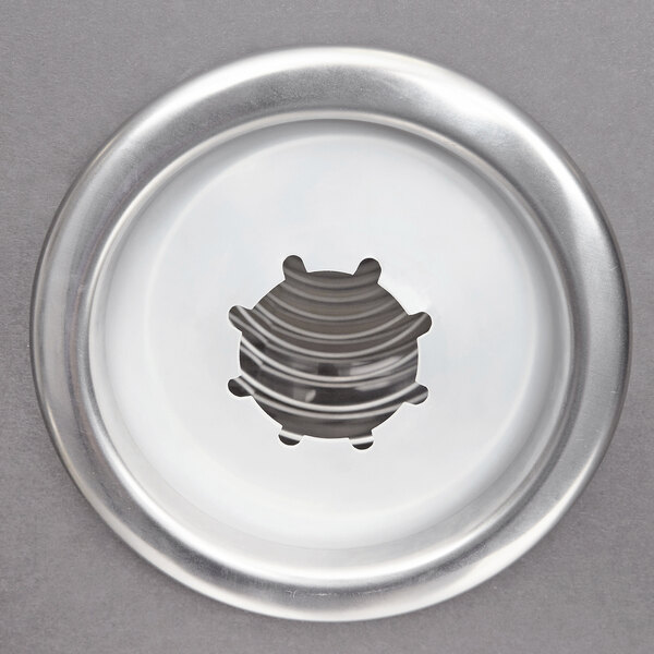 A circular silver metal plate with a small hole in the middle.