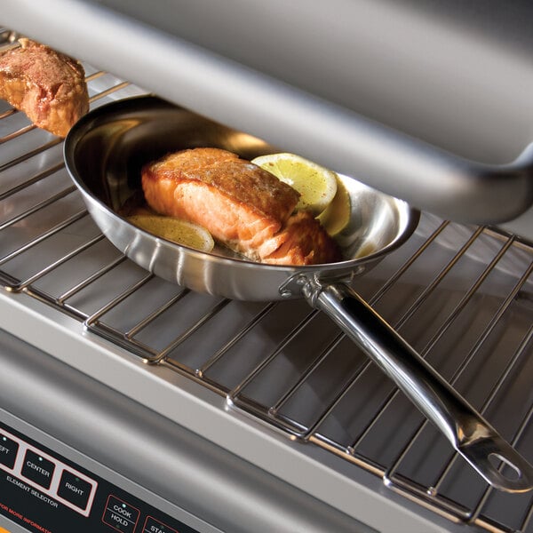 A pan with salmon and lemon wedges on a Hatco countertop salamander rack.