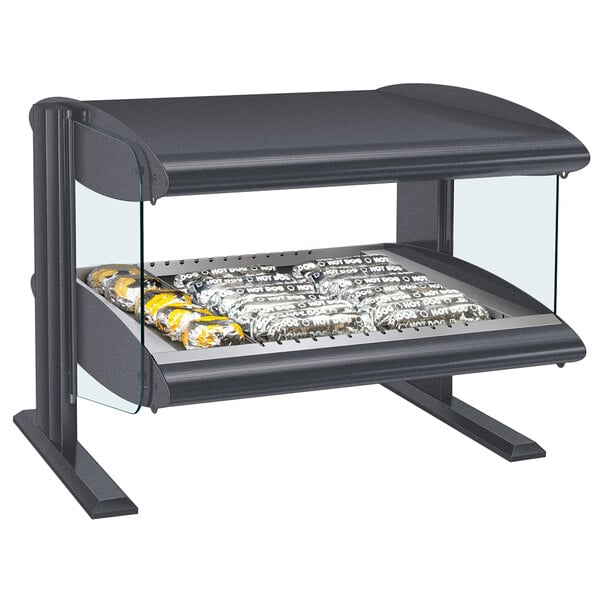 A Hatco countertop heated zone merchandiser with food on a glass shelf.